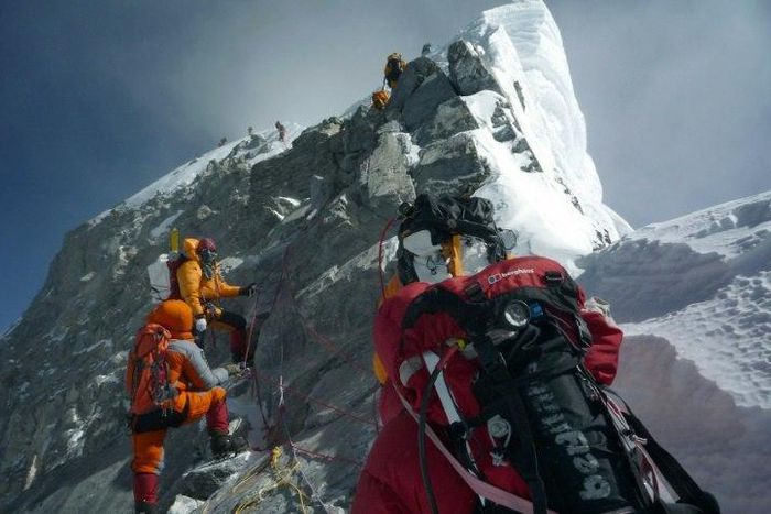 Mountaineers walk past the Hillary Step while pushing for the summit of Mount Everest