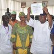 Otunba Ademola Adeleke raises his certificate of return above his head after it was presented to him by the Independent National Electoral Commission (INEC) on Tuesday, July 11, 2017