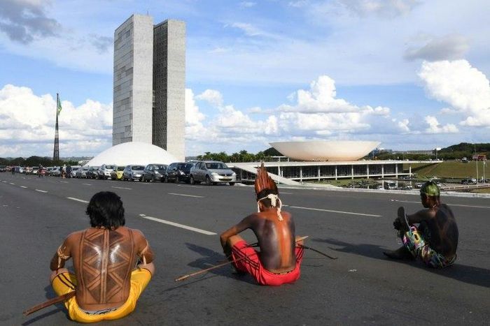Brazilian indigenous people block a road as they sit in front of the National Congress during the annual march for their rights, in Brasilia, on April 25, 2017