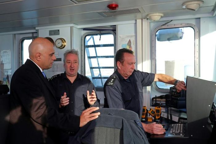 Britain's Home Secretary Sajid Javid (L) talks with UK Border Force staff onboard of Border Force cutter, HMC Searcher, on the Dover Strait off the coast of Dover, in south-east England