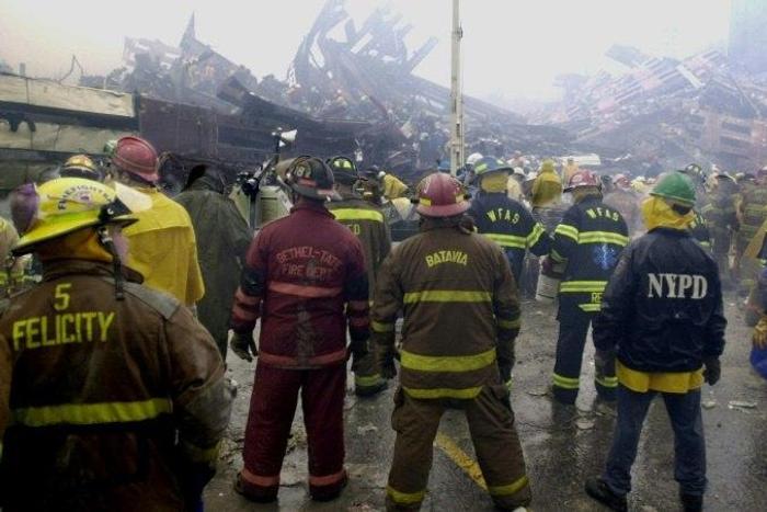 Firemen and rescuers work at the base of the World Trade Center in the early morning September 14, 2001, in New York