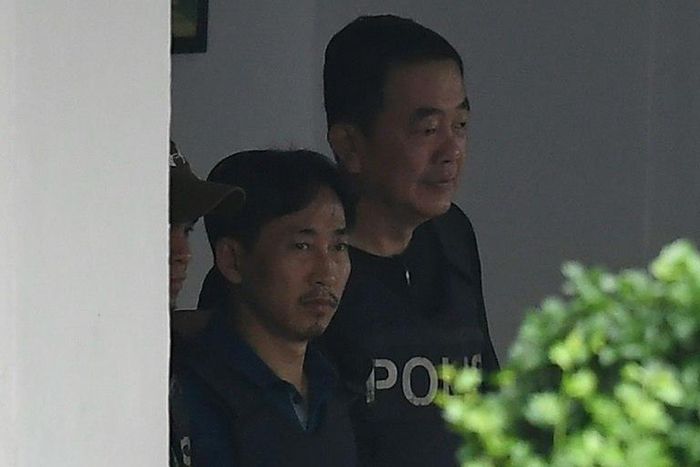 North Korean national Ri Jong Chol (L) is escorted by police officers as he leaves the Sepang police headquaters, on March 3, 2017
