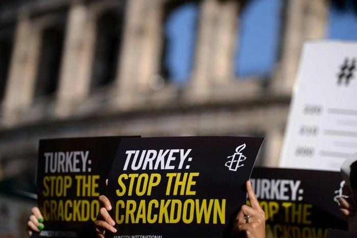 Amnesty International activists hold placards as they protest against the arrest of rights activists in Turkey, including Amnesty International's Turkey director, on July 20, 2017, near the Coliseum in Rome