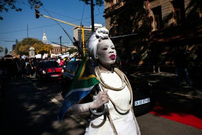 A woman dressed in a wedding gown and holding a South African flag leads a march in Pretoria against the abuse of women following the spike in reports of women being murdered and raped in various parts of the country