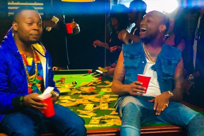 Olamide and Davido holding red cups