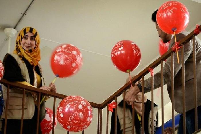 A member from the "Rebirth Generation", a group of Iraqi youths who are trying to revive the embattled city of Mosul, distributes balloons as they organise an event to mark Valentine's Day on February 14, 2017