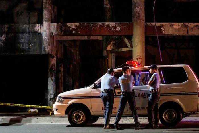 Police officers photographed at a crime scene in Manila on December 23, 2016