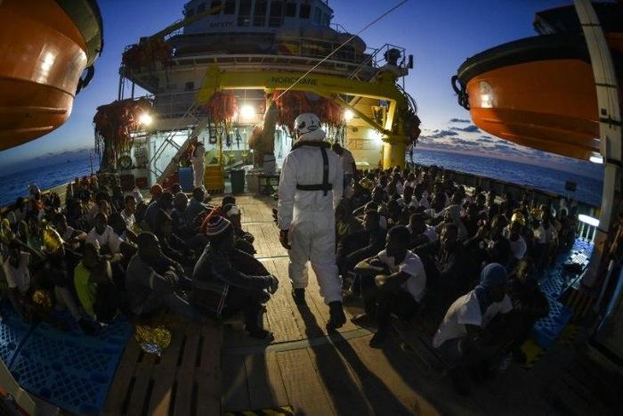 Migrants and refugees wait to be trasferred from the Topaz Responder ship in November 2016