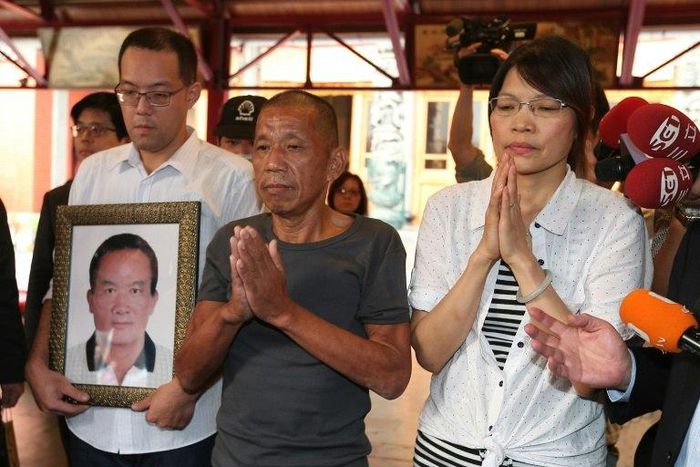 Shen Jui-chang (C), who was the chief engineer on a fishing boat that was seized south of the Seychelles in March 2012, prays at Hsing Tian Kong temple in Taipei City on October 26, 2016