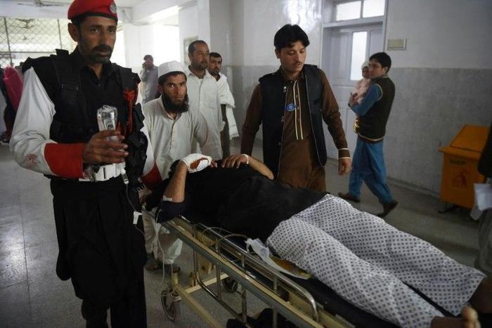 Medics move an injured member of the security personnel at a hospital in Peshawar on February 15, 2017, after a suicide bombing on a government compound in Mohmand tribal agency in Pakistan's northwest