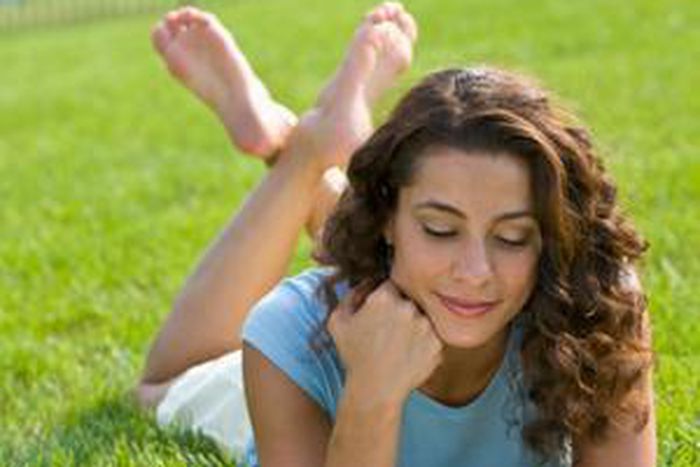 woman reading book on grass