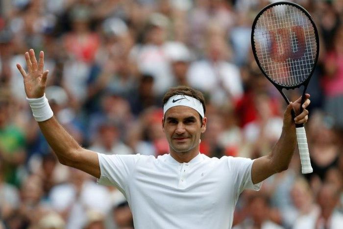 Switzerland's Roger Federer waves to the crowd as he celebrates beating Serbia's Dusan Lajovic during their men's singles second round match on the fourth day of the 2017 Wimbledon Championships July 6, 2017