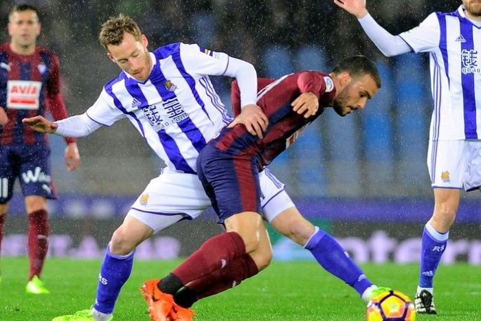 Real Sociedad's midfielder David Zurutuza (L) vies with Eibar's midfielder Pedro Leon during the Spanish league football match Real Sociedad vs SD Eibar at the Anoeta stadium in San Sebastian on February 28, 2017