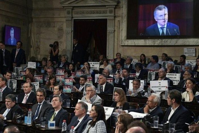 Opposition legislators hold banners as they listen to the speech of Argentina's President Mauricio Macri during the inauguration of the 135th period of ordinary sessions at the Congress in Buenos Aires on March 1, 2017