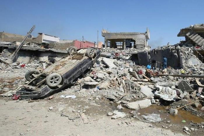Iraqis inspect the rubble of destroyed houses in the Mosul al-Jadida area, following air strikes in March 2017