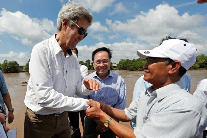US Secretary of State John Kerry (L) shakes hands with Vo Ban Tam, 70, who was a member of the former Viet Cong guerrilla and who took part in the attack on Kerry's Swift Boat on February 28, 1969