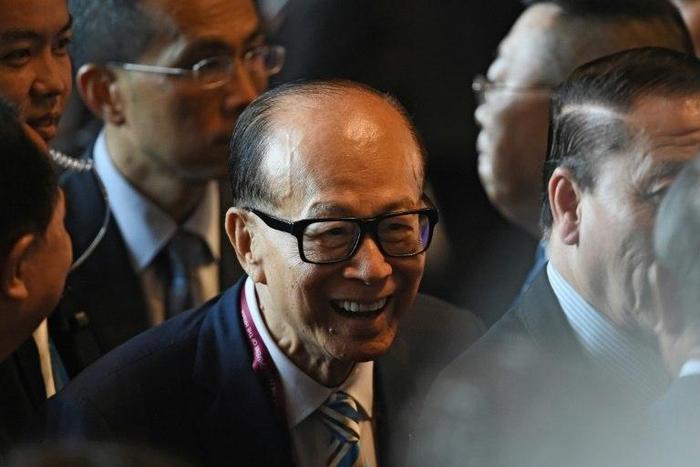 Hong Kong tycoon Li Ka-shing (C) said he was "cautiously optimistic" about his company's future, as an upturn in major economies was weighed by geopolitical risks