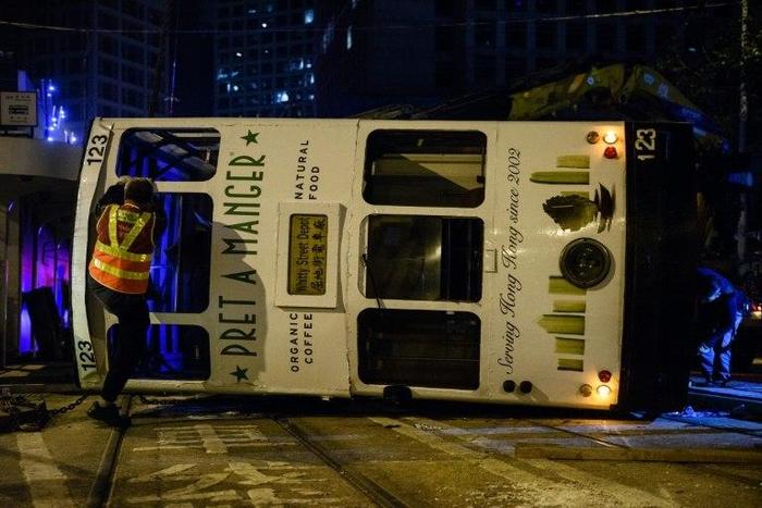 Five women and nine men were injured when a Hong Kong tram flipped over in the city's financial district in the early hours of Thursday