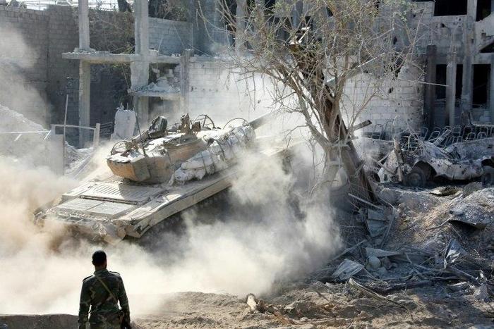 A pro-government tank is driven across rubble in Qabun district, on the outskirts of the Syrian capital Damascus, on May 13, 2017