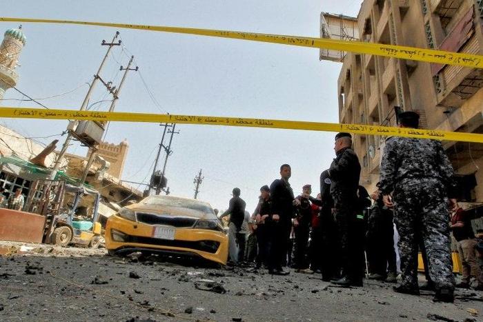 Iraqis gather at the site of a car bombing near Baghdad's Al-Shuhada Bridge on May 30, 2017 which killed at least 11 people