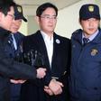 Samsung Group's heir-apparent Lee Jae-Yong (C) arrives in handcuffs for questioning at the office of a special prosecutor investigating a corruption scandal in Seoul on February 18, 2017