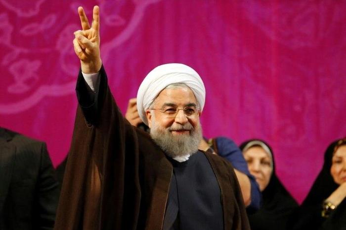 Iranian President Hassan Rouhani, who has comfortably won a second term, gestures during a campaign rally in Tehran on May 9, 2017
