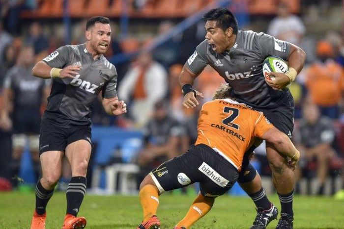 The Central Cheetahs' Torsten van Jaarsveld (C) tackles the Canterbury Crusaders' Seta Tamanivalu during their Super Rugby match, at the Bloemfontein stadium in South Africa, on April 29, 2017