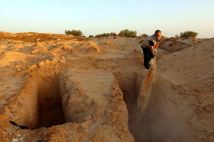 Unemployed former fisherman Chamseddine Marzouz digs a grave at a makeshift cemetery for migrants on July 12, 2017 in the Tunisian town of Zarzis