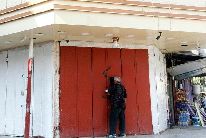 An Iraqi man buys liquor from a shop selling it illegaly through a window in the capital Baghdad on October 23, 2016