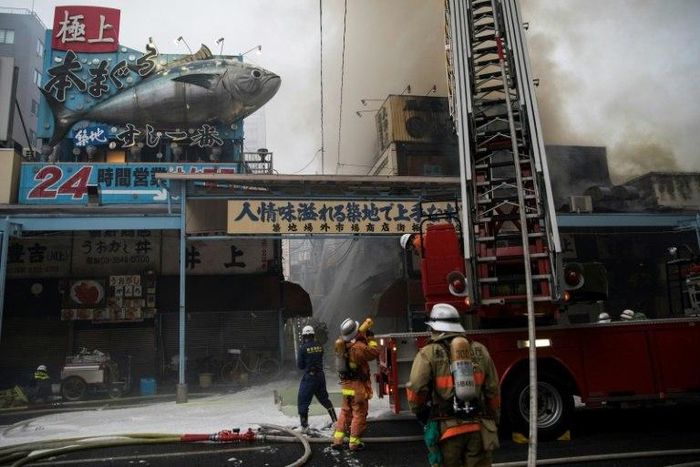 Japanese firefighters try to extinguish a fire at Tokyo's Tsukiji fish market on August 3, 2017