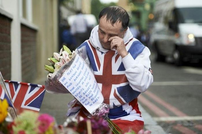A man lays flowers at a makeshift memorial near Borough Market in London