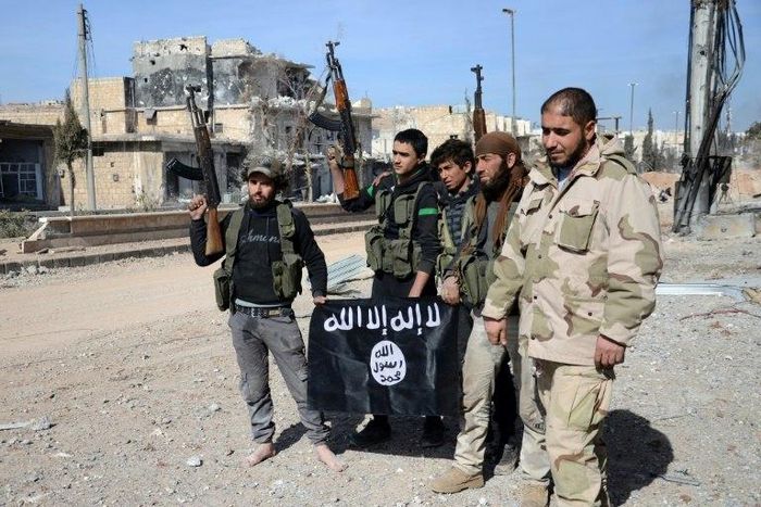 Rebel fighters, part of the Turkey-backed Euphrates Shield alliance, pose with an Islamic State group flag as they advance on February 20, 2017, towards the city of Al-Bab, some 30 kilometres from the Syrian city of Aleppo