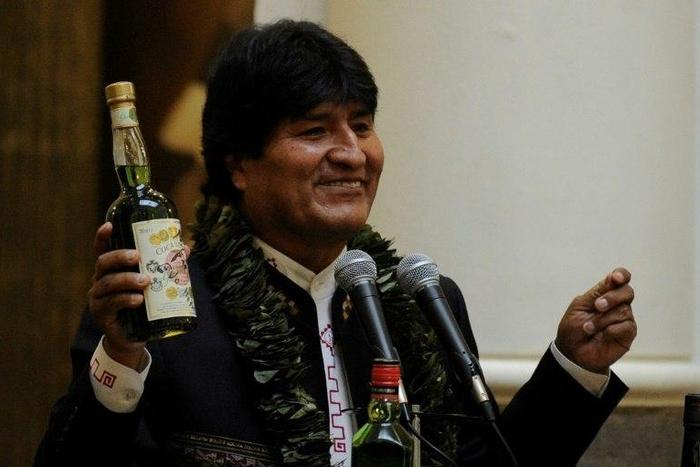 Bolivian President Evo Morales shows a bottle containing a coca-based drink during the ceremony to promulgate a government bill increasing the legal areas of cultivation of coca, at the Quemado presidential palace in La Paz, on March 8, 2017
