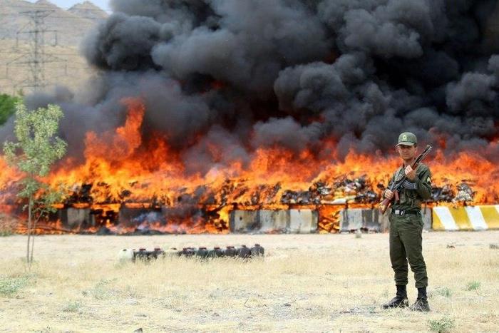 An Iranian policeman stands guard as 50 tonnes of illegal drugs are destroyed during a ceremony on June 27, 2015 in the northeast city of Mashhad