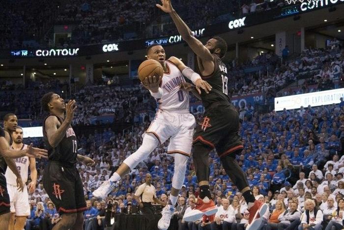 Russell Westbrook of the Oklahoma City Thunder drives around James Harden of the Houston Rockets during Game Three in the Western Conference Quarterfinals