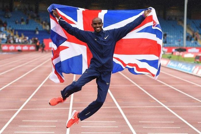 Britain's Mo Farah poses with a national flag after winning the men's 3,000m during the 2017 IAAF Birmingham Diamond League athletics on August 20, 2017