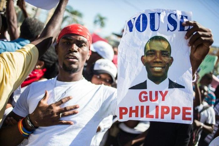 A supporter of Guy Philippe holds a sign during protests in front of the US embassy in Tabarre, Haiti in January 2017