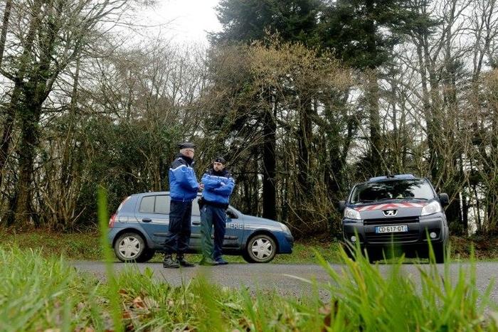 French gendarm block the access to a road, where a healthcare card in the name of Charlotte Troadec has been discovered by a runner on March 1, 2017, in Dirinon, some 20 km east of Brest, western of France