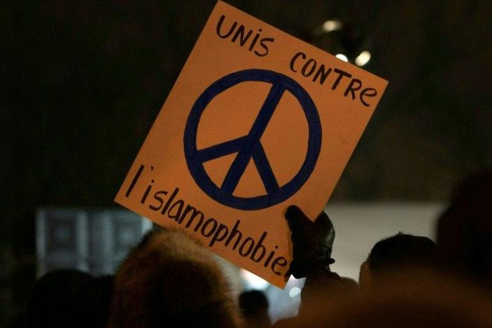 A person holds a sign "United against Islamophobia" during a rally near the Islamic Cultural Center in Quebec City, Canada on January 30, 2017
