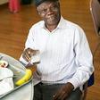 Older African American man making healthy eating choices for his diet with a glass of milk.