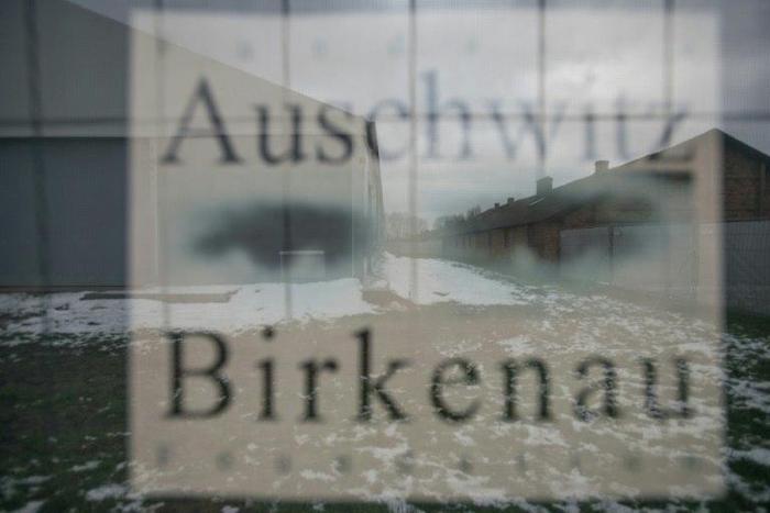 Barracks are seen through a poster at the former German nazi camp in Oswiecim (Auschwitz), Poland, on December 2, 2016, where US congressman Clay Higgins filmed and published a video deemed insensitive by Poland's chief rabbi