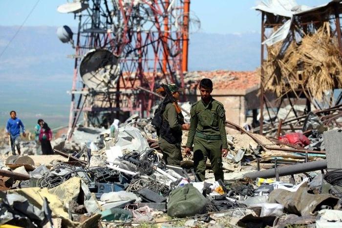 Fighters from the Kurdish People's Protection Units (YPG) and Kurdish police, known as the Asayish, visit the site of Turkish airstrikes near northeastern Syrian Kurdish town of Derik, known as al-Malikiyah in Arabic, on April 25, 2017