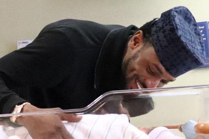 A happy D'banj smiles at his new born child, Daniel.