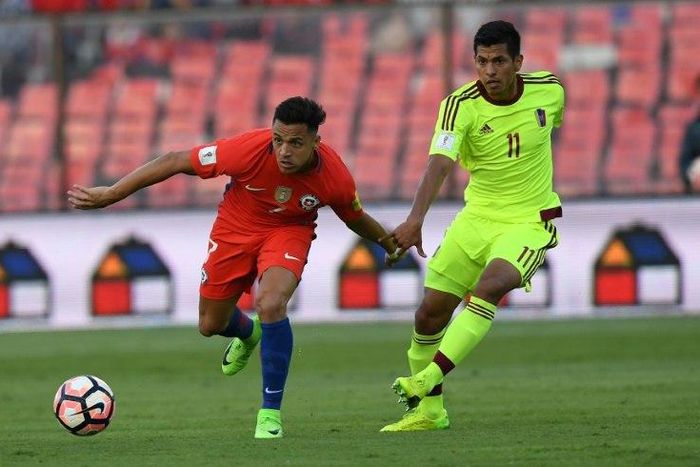 Chile's Alexis Sanchez (L) fights for the ball with Venezuela's Renzo Zambrano during their Russia 2018 World Cup qualifier match, in Santiago, on March 28, 2017