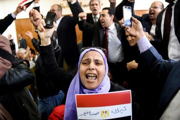 An Egyptian woman holds a national flag scrawled with the words "Tiran" and "Sanafir" after the High Administrative Court upheld a ruling voiding an agreement to hand over the two Red Sea islands of Tiran and Sanafir to Saudi Arabia