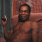 Fela, joint in hand, smiles for the camera during an interview at his home, Kalakuta Republic