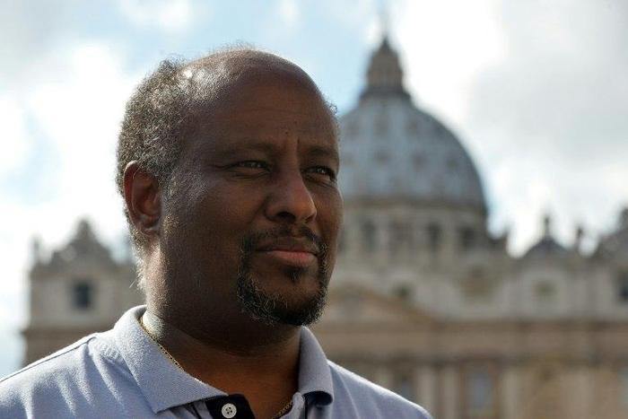 Eritrean priest Mussie Zerai poses in front of Saint Peter's basilica on October 4, 2015 in Vatican