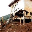 An excavator clears mud and debris after the partial collapse of a hillside in Freetown, Sierra Leone, that swept away hundreds of homes