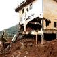 An excavator clears mud and debris after the partial collapse of a hillside in Freetown, Sierra Leone, that swept away hundreds of homes