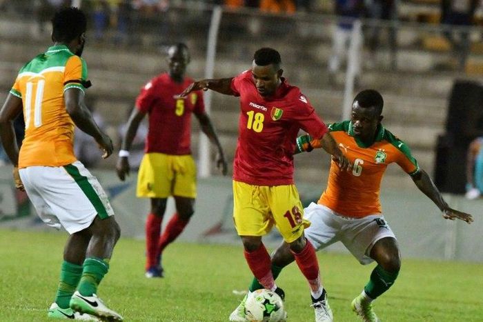 Ivory Coast's Jean Michael Seri (R) and Franck Kessie (L) fight for the ball with Guinea's Seydouba Soumah (C) during the 2019 Africa Cup of Nations qualifying football match June 10, 2017
